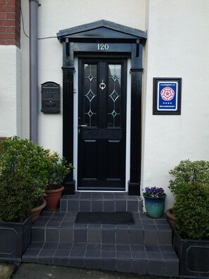 A black door with the number 120, a mailbox, and a plaque on the wall. - The Post House (Ibstock)