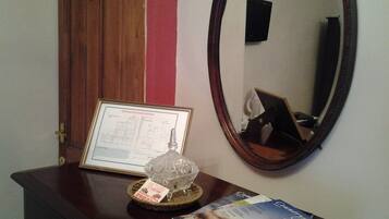 A wooden dresser with a framed certificate, a decorative glass object, and a magazine.