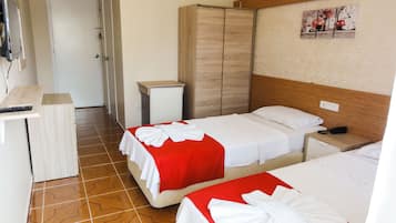 Une chambre d’hôtel avec deux lits, un petit bureau, une armoire et un téléviseur.