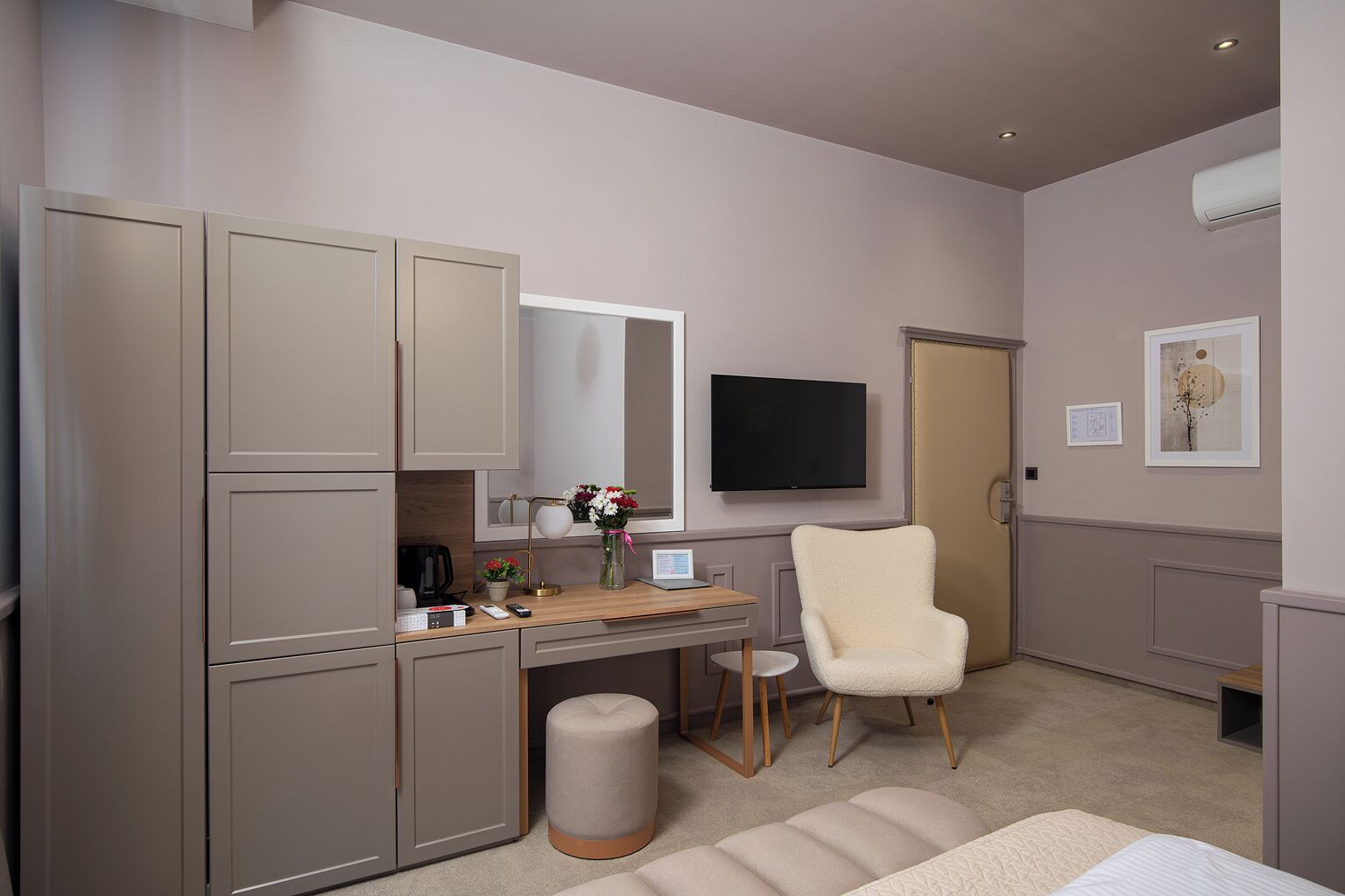 Un dormitorio con escritorio, silla, armario y televisor.