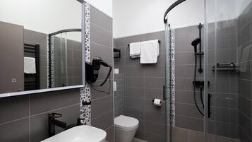 A modern bathroom with a shower, toilet, and sink.