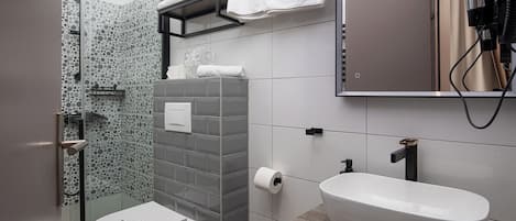 A modern bathroom with a toilet, sink, and shower.