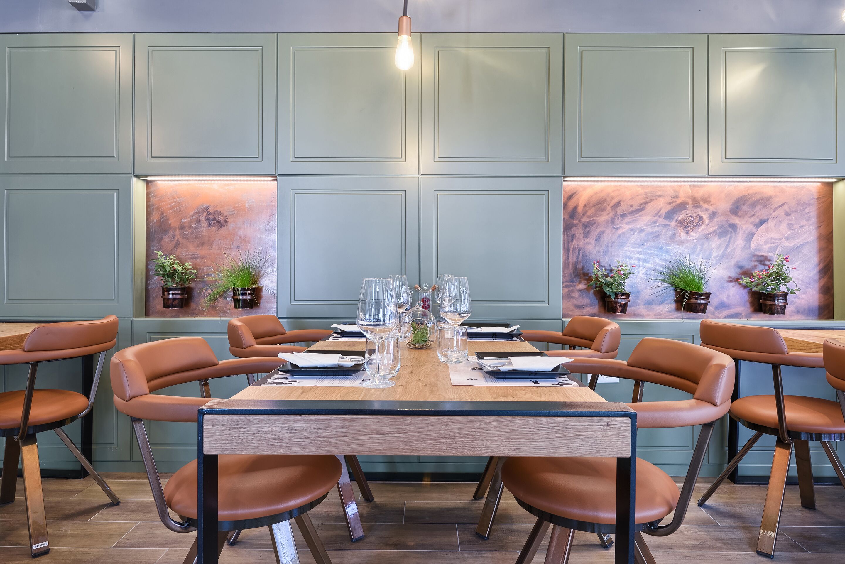 A dining area with a wooden table, brown leather chairs, and a light fixture above.