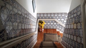 A staircase with ornate patterned tiles on the walls and a wooden handrail. - Hotel Aliança (Figueira da Foz)