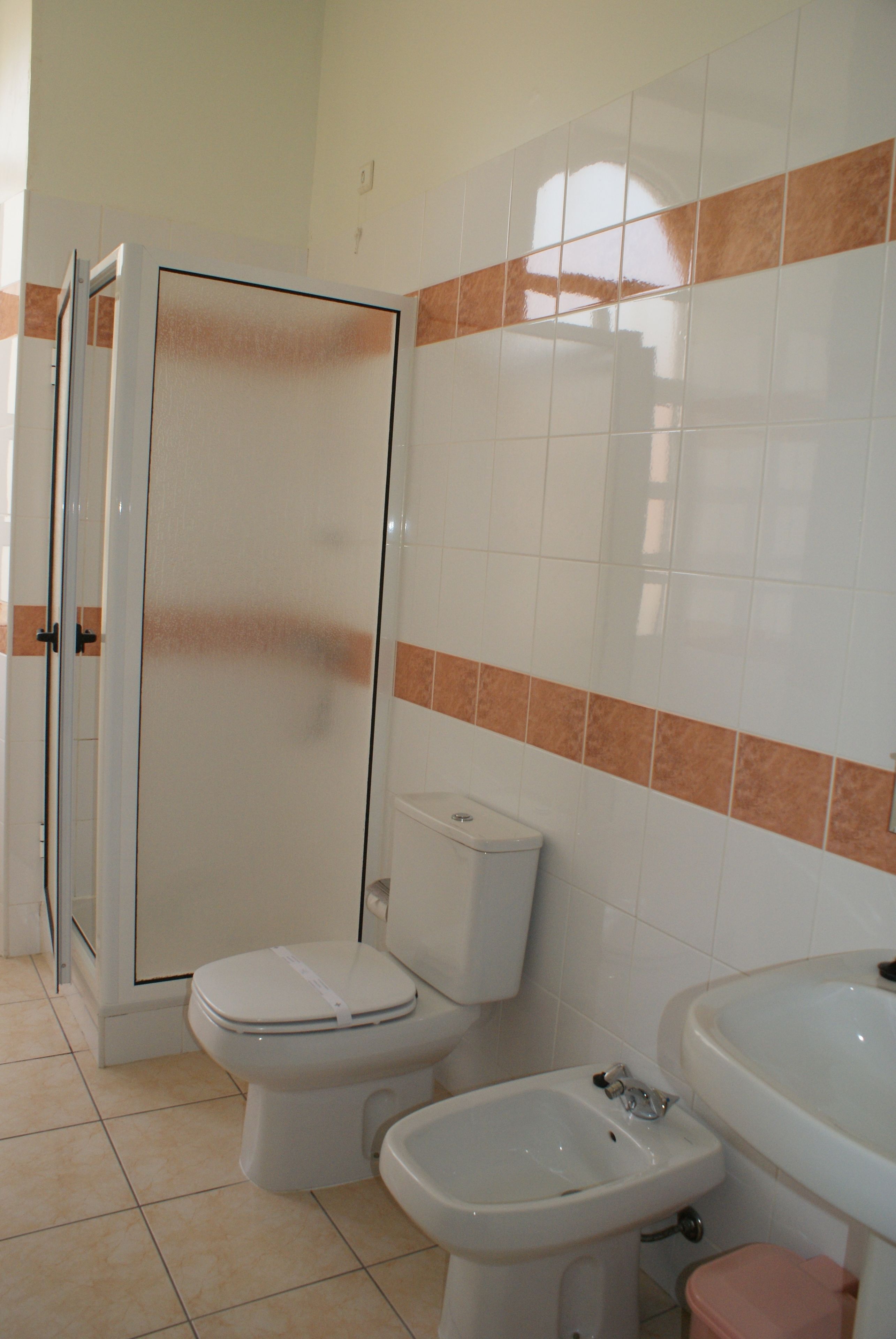 A bathroom with a toilet, bidet, and sink.