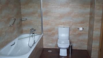 A bathroom with a bathtub, toilet, and shower.