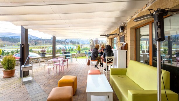 An outdoor patio area with seating, a table, and a view of the landscape.