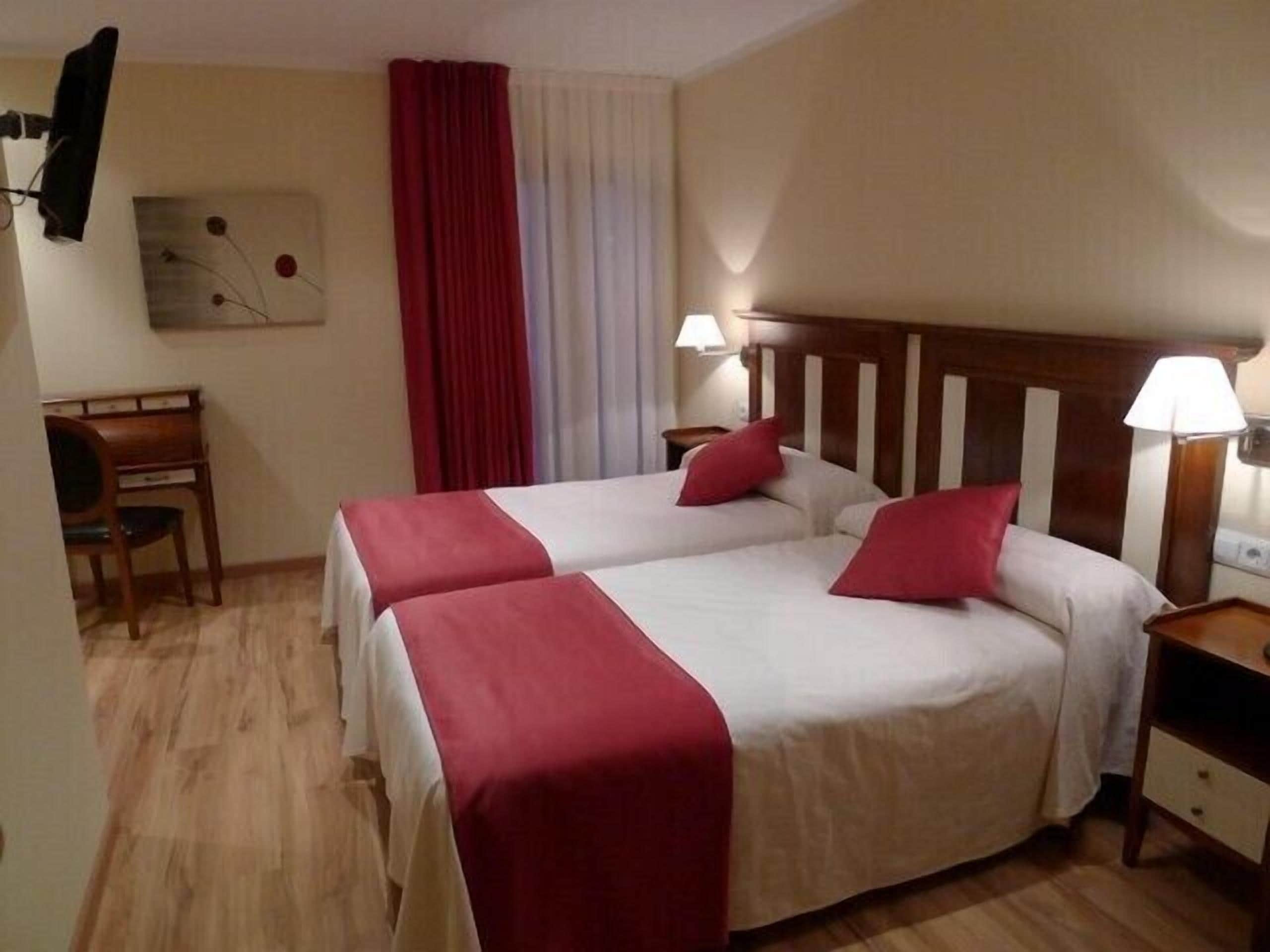 Una habitación de hotel con dos camas, un escritorio y una silla.