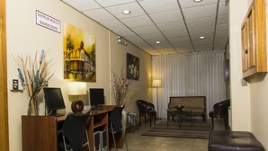 A business center with a desk, chairs, a sofa, and a TV. - Hotel Don Eduardo (Temuco)