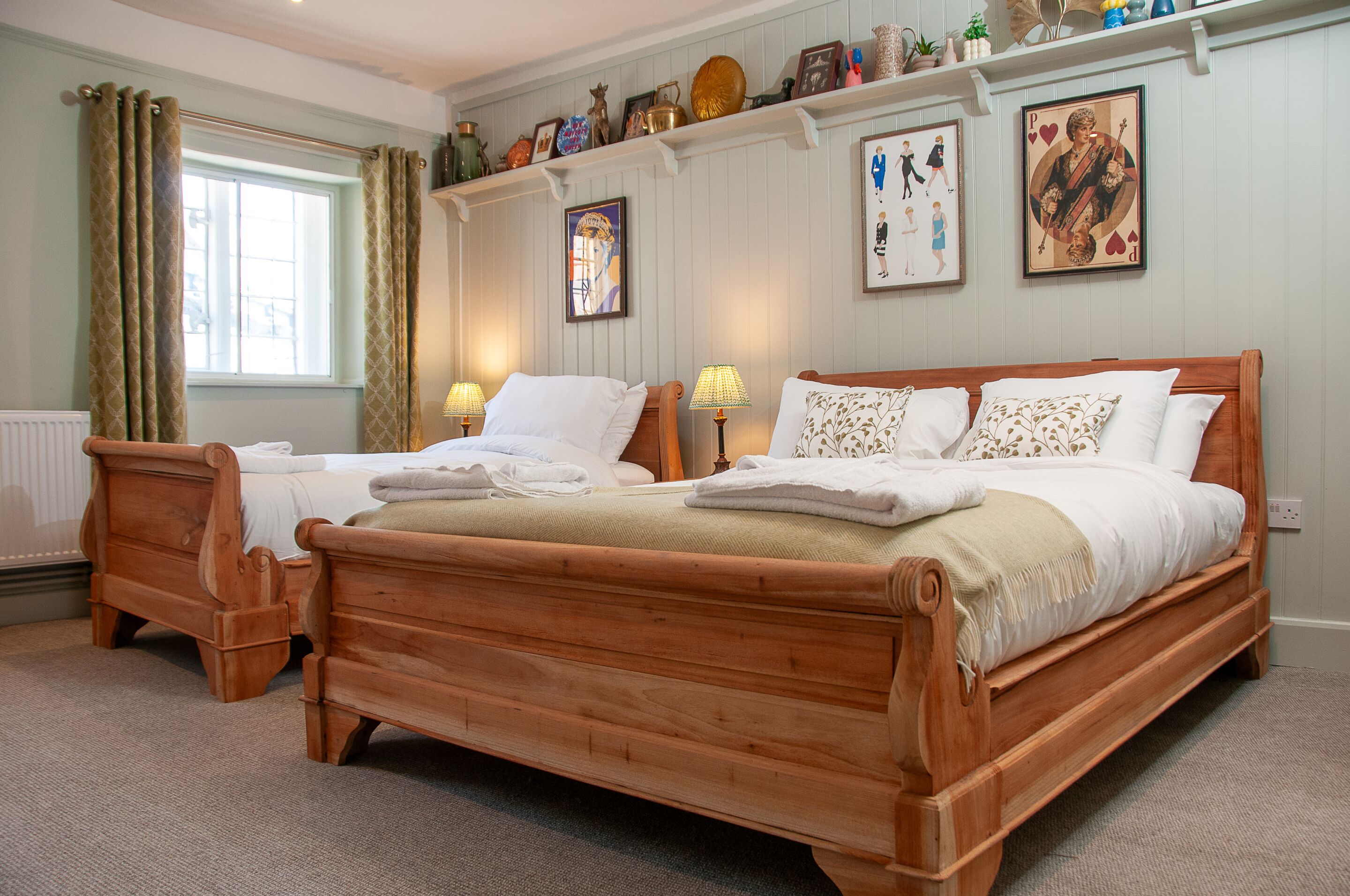 A double bed with a wooden frame, two bedside tables, and a window with curtains.
