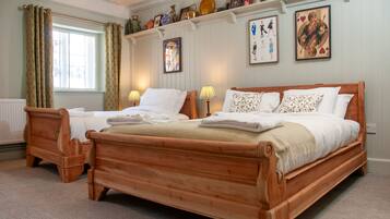 A double bed with a wooden frame, two bedside tables, and a window with curtains.