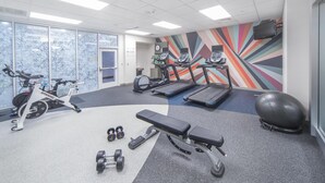A gym with cardio equipment, dumbbells, and a bench. - Hilton Garden Inn Clifton Park (Clifton Park)