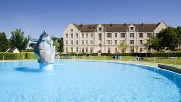 Experience the serene atmosphere of our resort, surrounded by lush gardens and a tranquil pool with a central fountain.