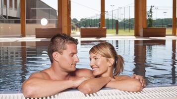 Een binnenzwembad, een buitenzwembad en ligstoelen