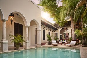 Una piscina al aire libre, sillones reclinables de piscina