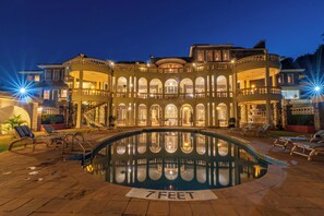 Relax by the 7-foot deep pool surrounded by elegant architecture and multiple balconies.