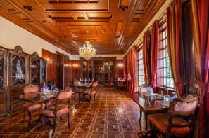 Classic dining room with a long table, tufted chairs, and a chandelier.