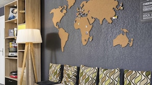 A modern seating area with a world map wall, a lamp, and a small table.