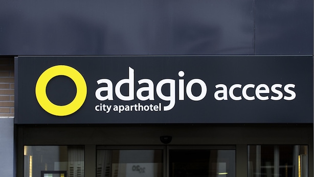 A building with a sign reading "Adagio Access city apartment hotel".