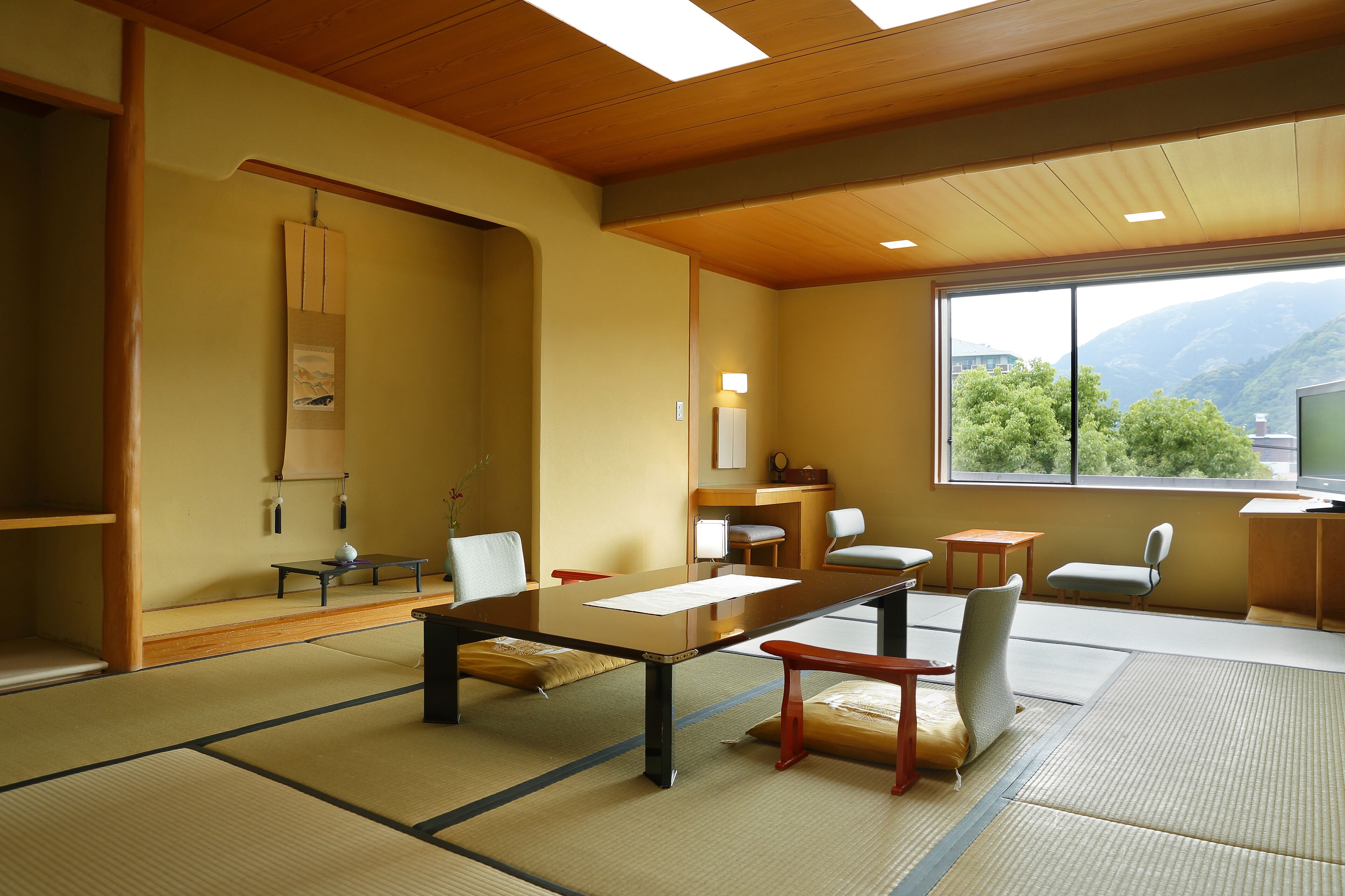 A traditional Japanese room with tatami flooring, a low table, and seating.