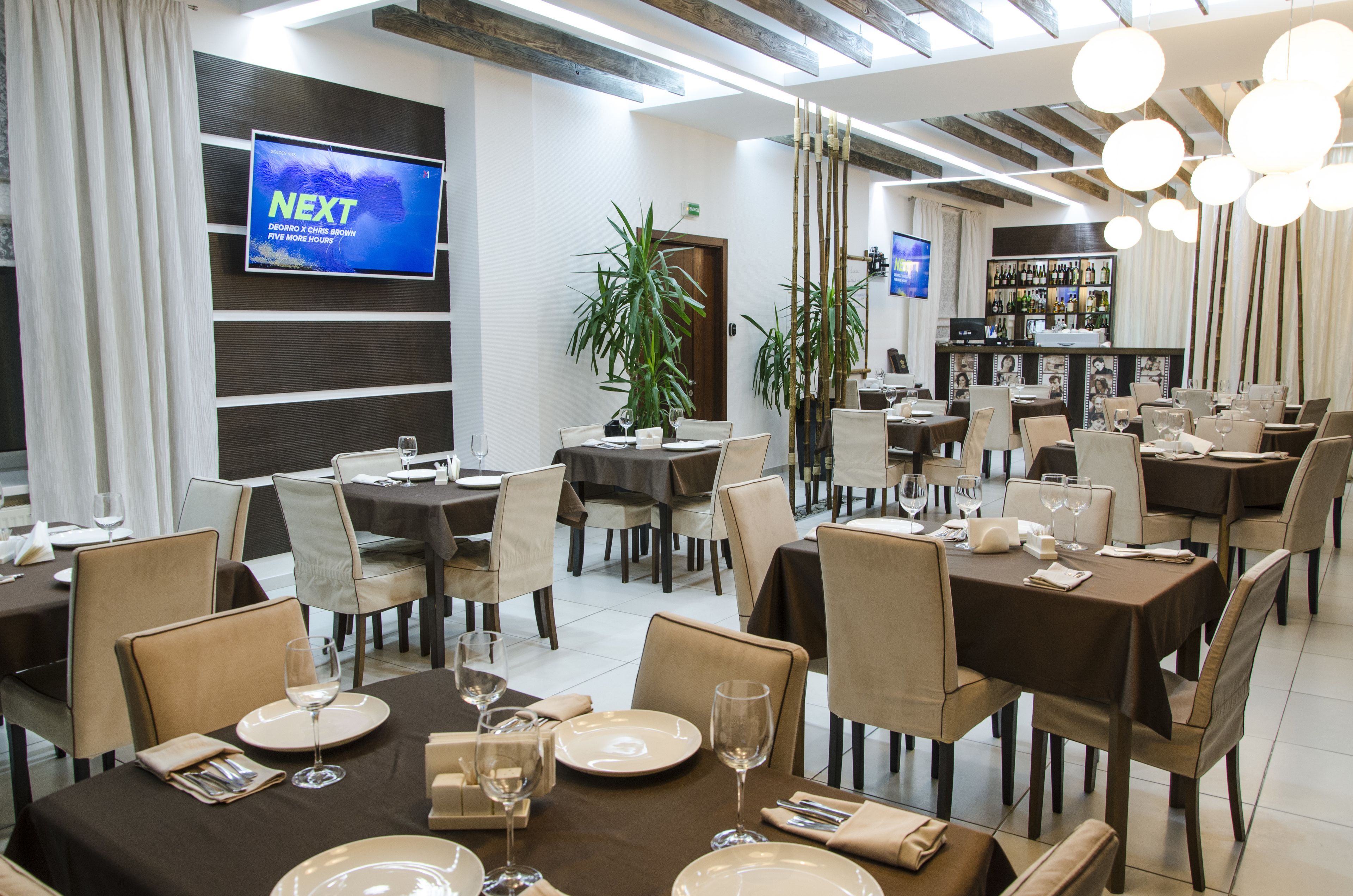 A restaurant with multiple tables, chairs, and a bar area.