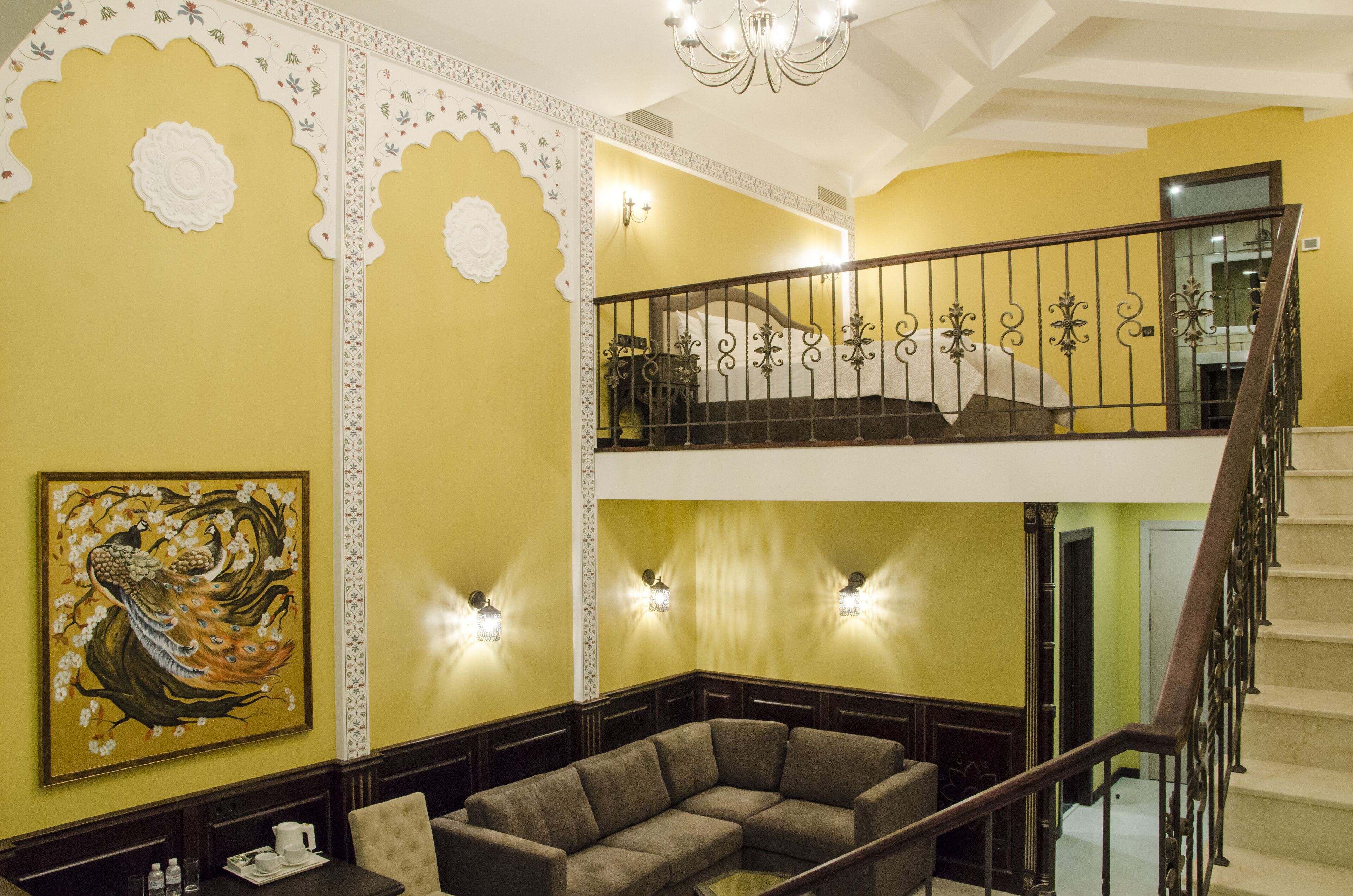 Un interior de varios niveles con una escalera, un comedor y una pared con diseños decorativos.