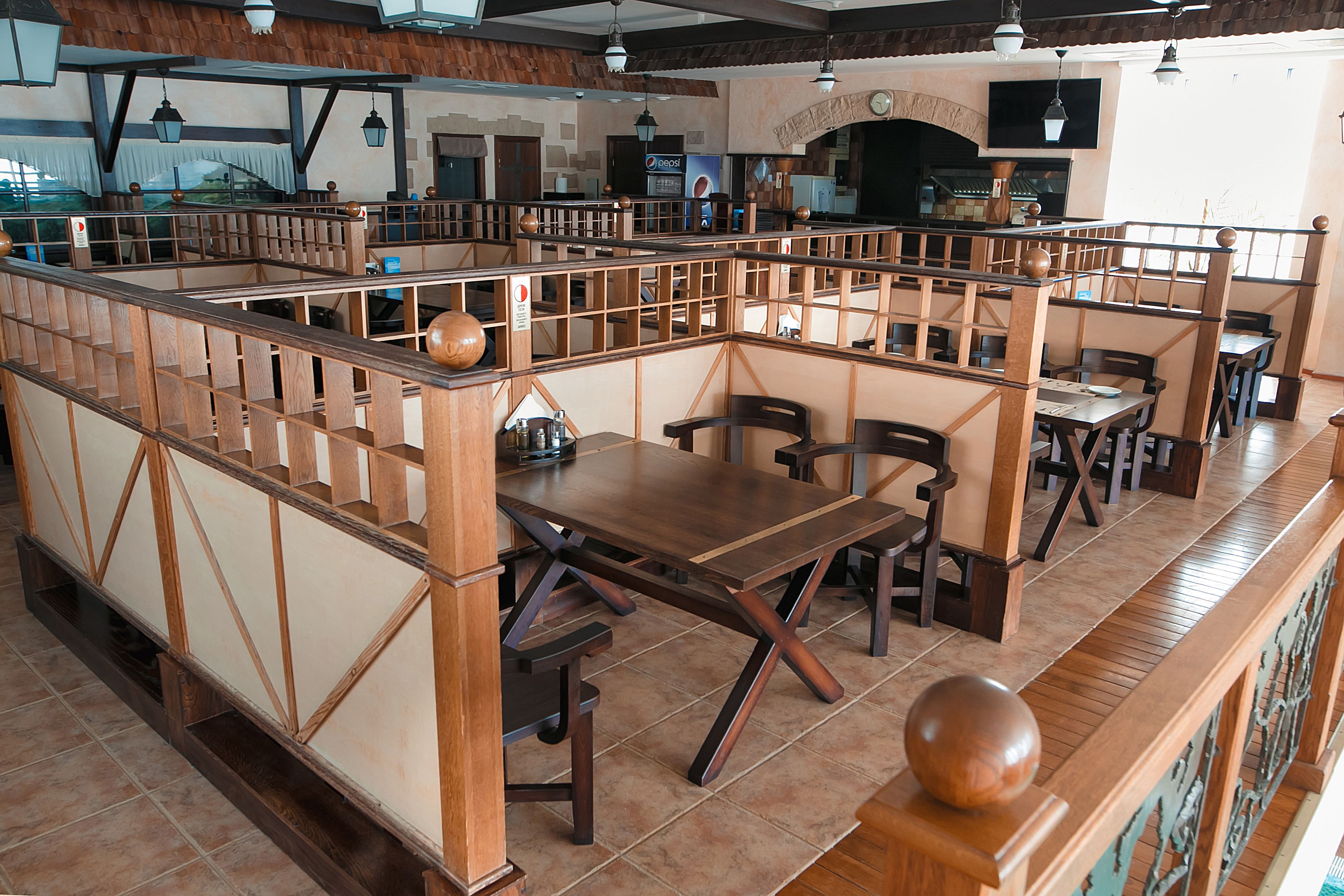 Ein Restaurantinneres mit Holzkabinen, Fliesenböden und einer Theke.