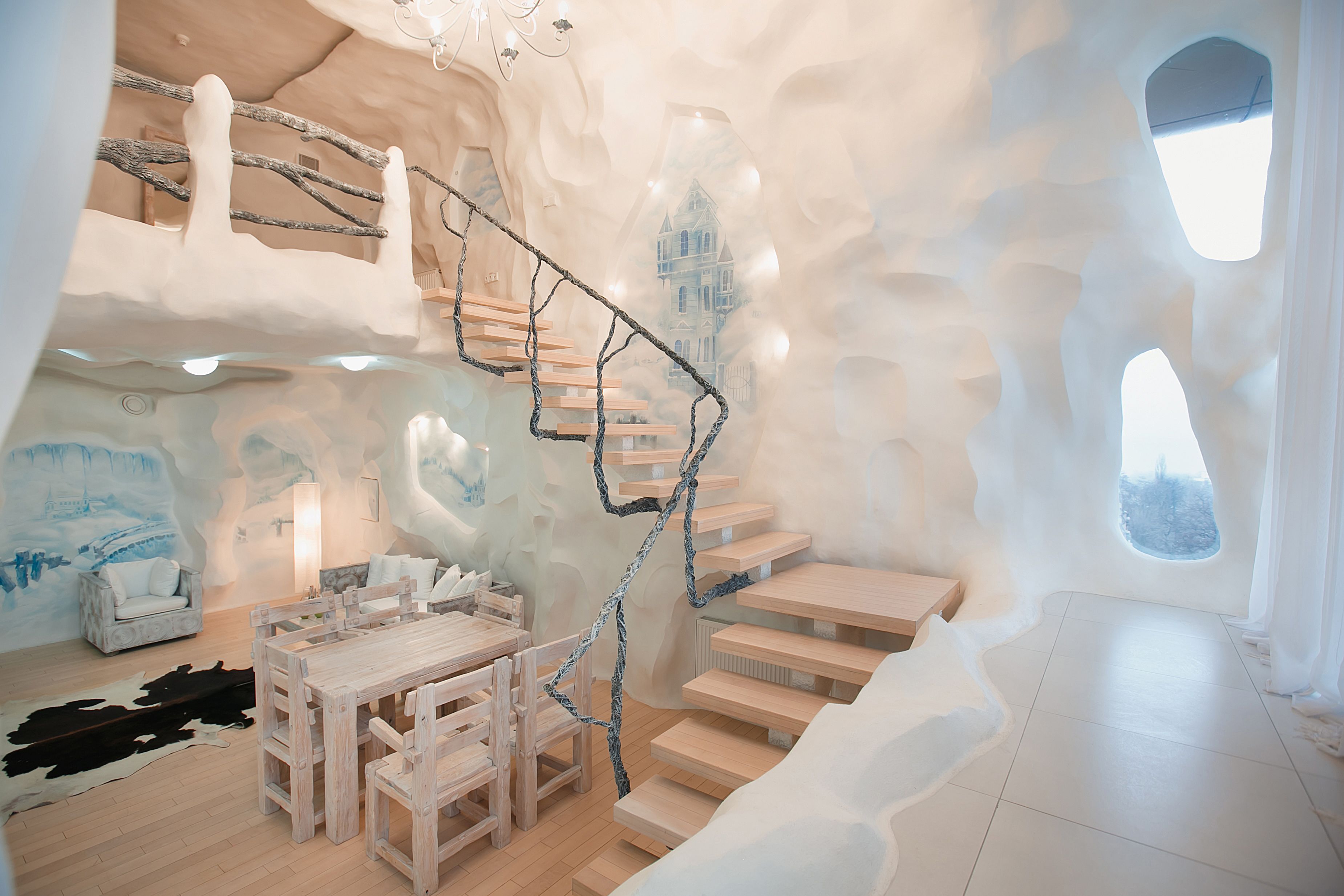 A room with a wooden staircase, a dining table, and chairs.