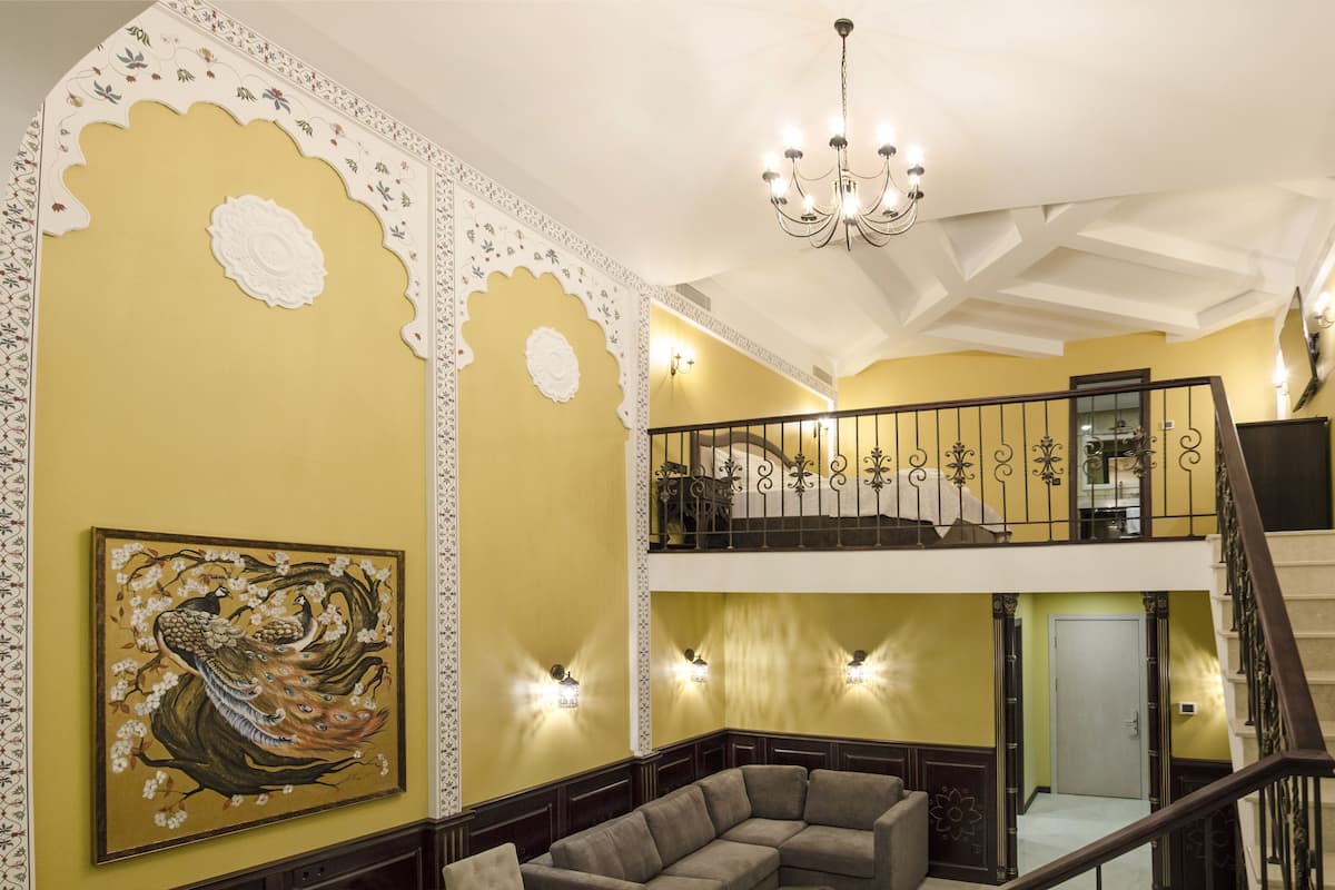 A multi-level interior with a staircase, decorative wall panels, and a chandelier.