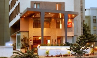 A modern hotel with a prominent reception area, large windows, and a sign for 'Citrus Hotels'.