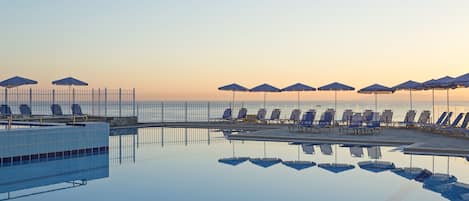 Una piscina cubierta, una piscina al aire libre de temporada, sombrillas