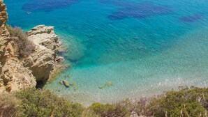A coastal landscape with clear turquoise waters, rocky cliffs, and boats. - Peninsula Resort & Spa - All Inclusive (Malevizi)