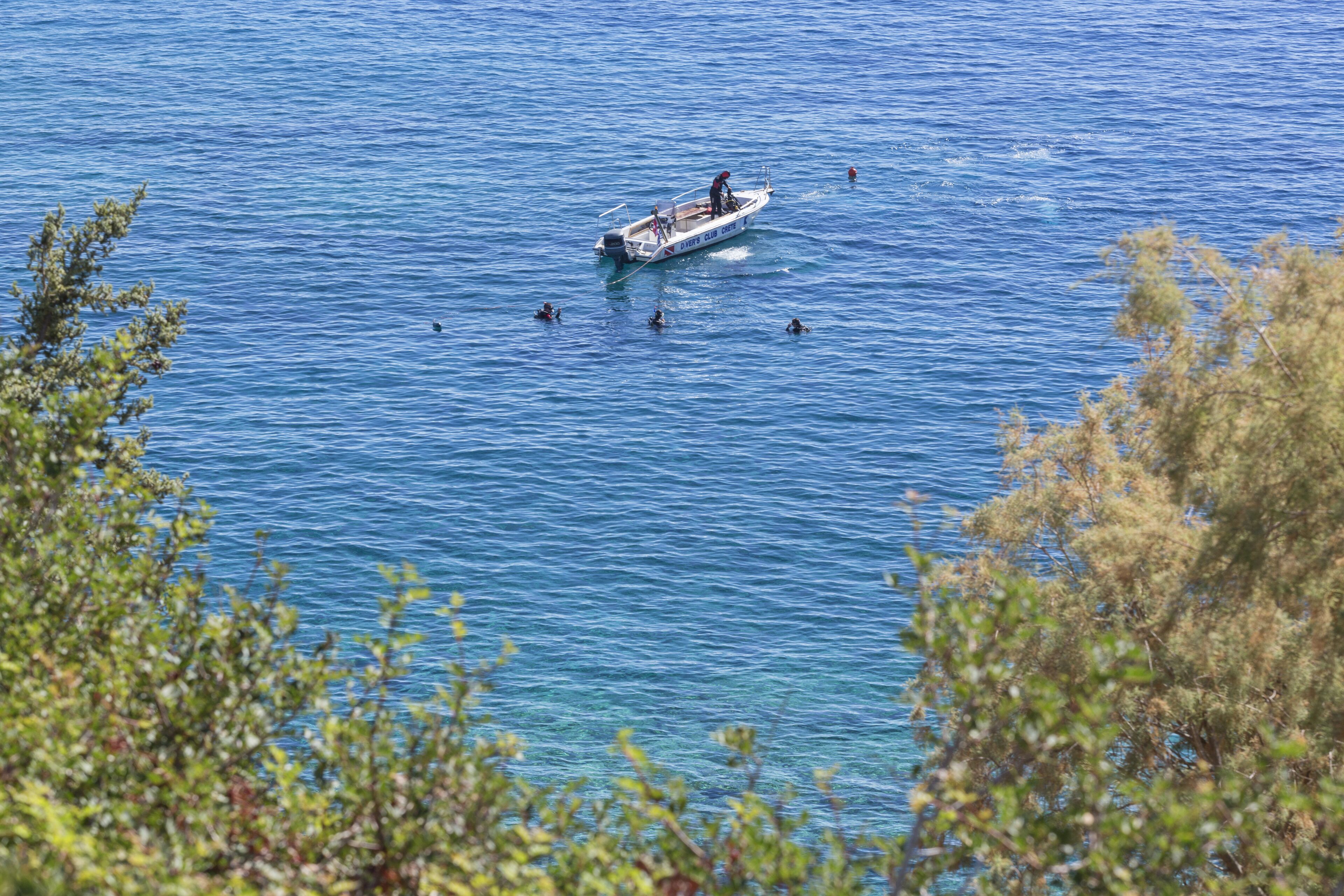 Um barco em águas calmas, com pessoas nadando ao redor.