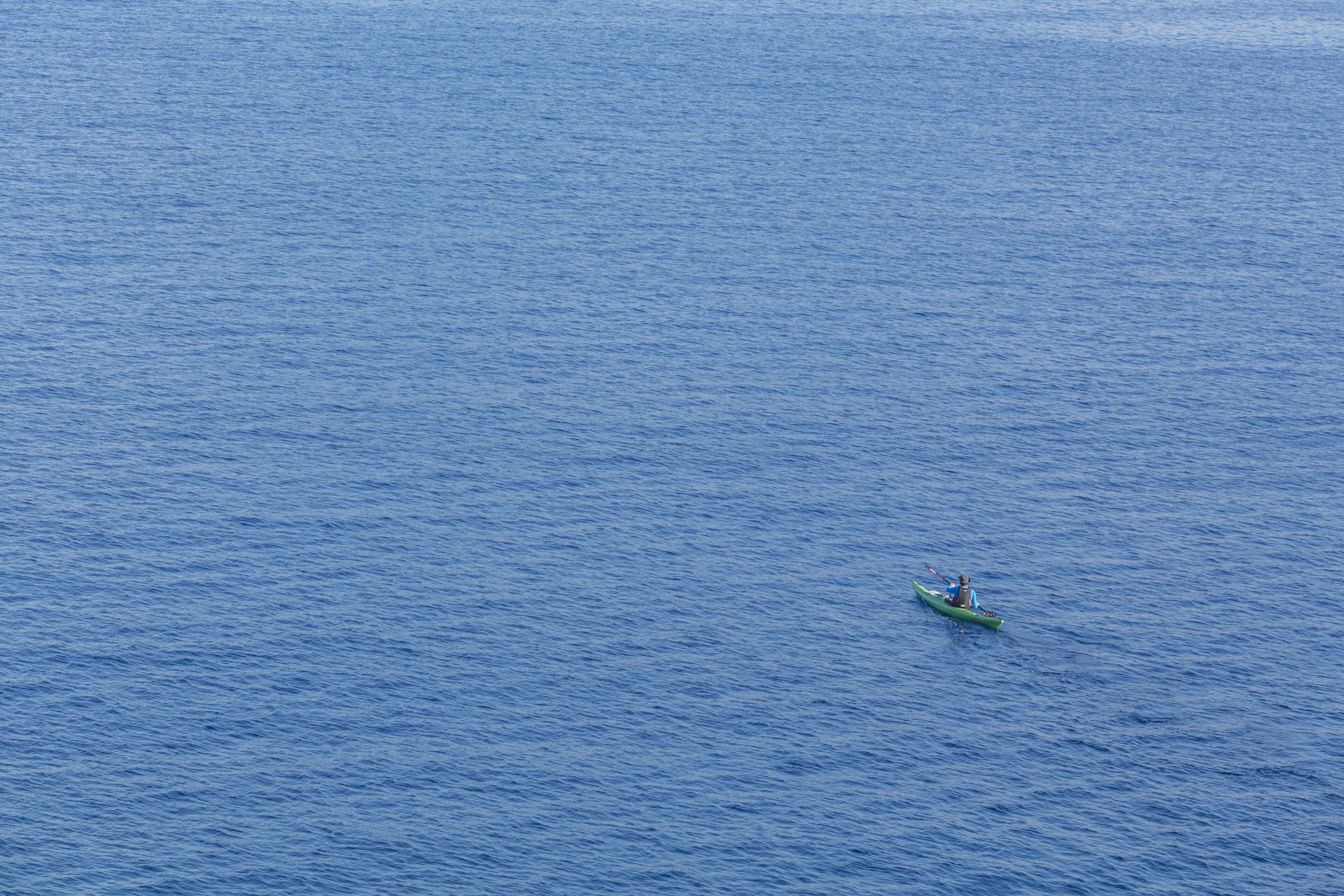 A single kayak on a vast, calm body of water.