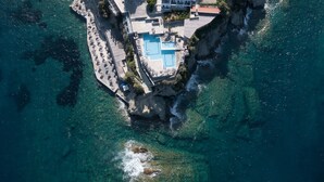 An aerial view of a coastal resort with a large pool, multiple buildings, and a tennis court. - Peninsula Resort & Spa - All Inclusive (Malevizi)