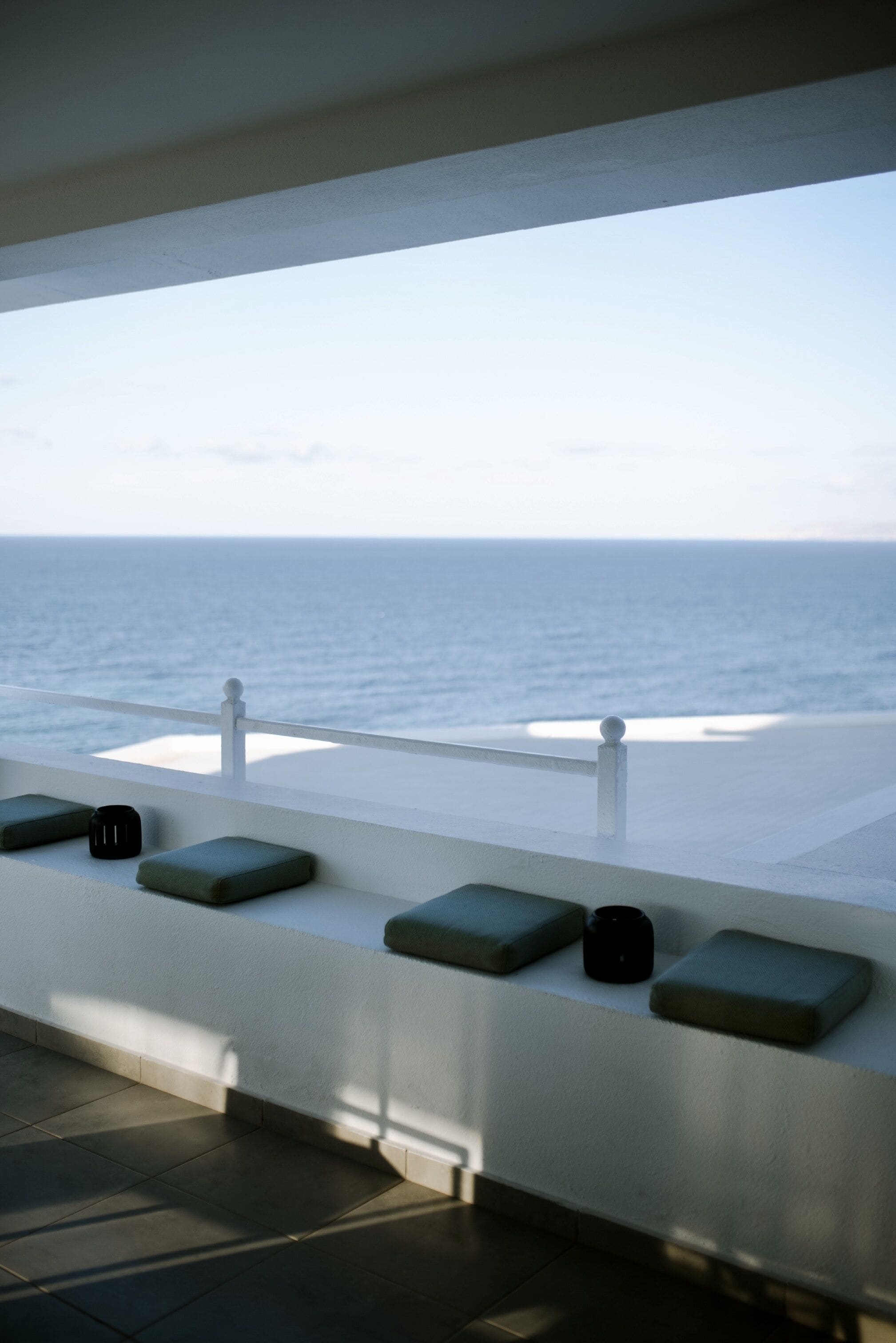 Un balcon avec vue sur l’océan, doté d ’une balustrade et de plusieurs coussins.