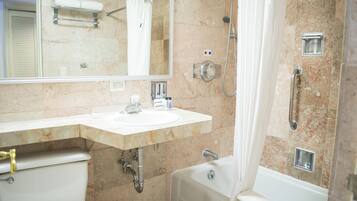 Un baño con lavabo, espejo, inodoro y bañera.