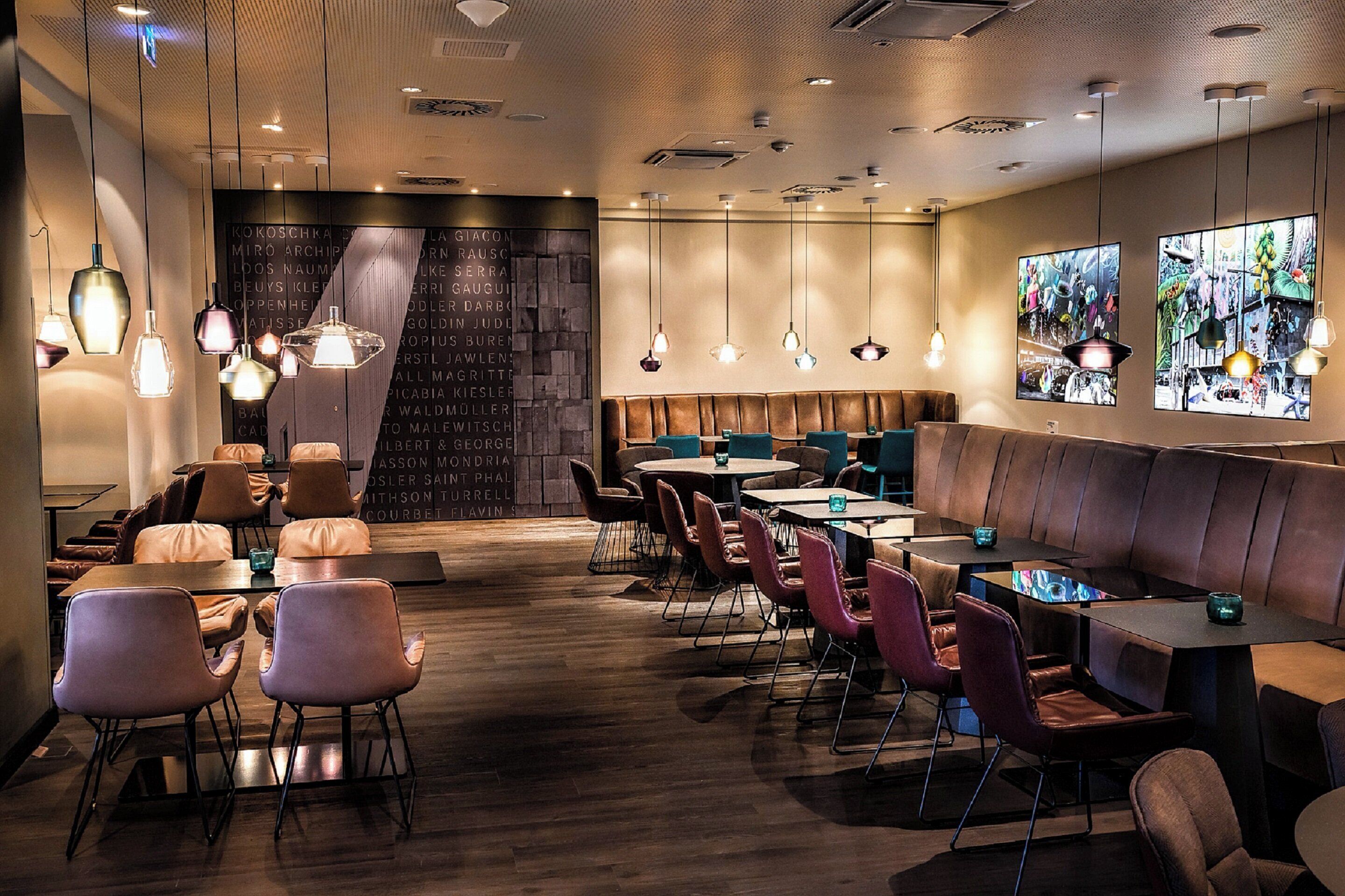 A modern restaurant with a variety of seating options including booths, tables, and chairs.
