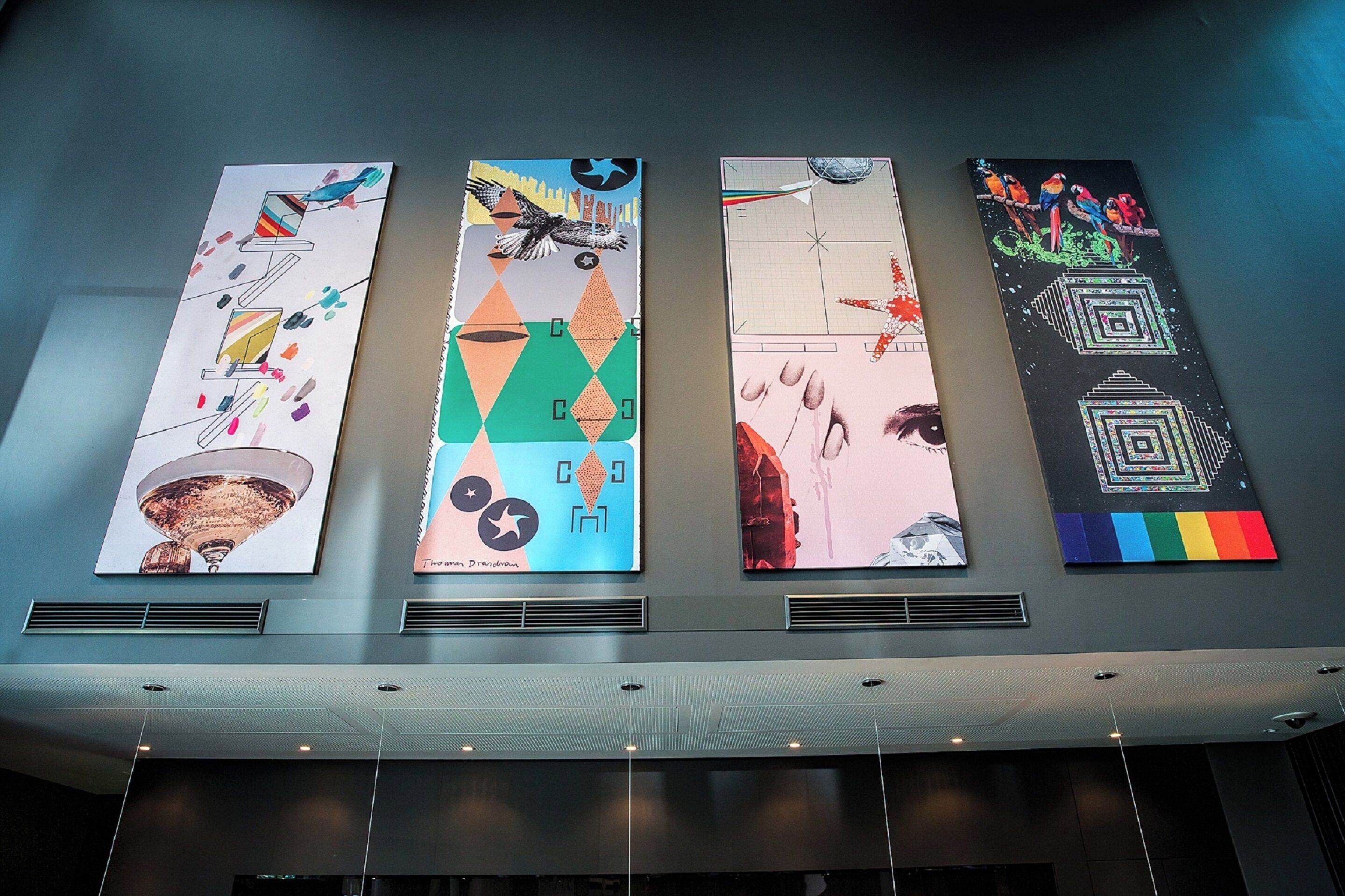 Four vertical banners with abstract designs and text on a wall.