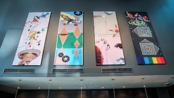 Four vertical banners with abstract designs and text on a wall.