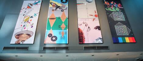 Four vertical banners with abstract designs and text on a wall.