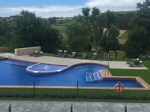 Alberca al aire libre y camastros 