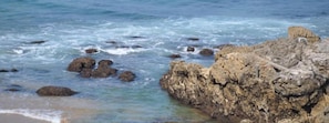 A rocky shoreline with clear blue water and waves. - Hotel Marfrei (Suances)