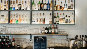 A bar area with shelves of liquor bottles and glasses. - Hotel Waltikka (Valkeakoski)