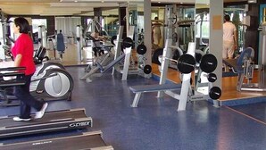 A gym with cardio equipment, weight machines, and mirrors. - Hotel Monte bello (Ajaltoun)
