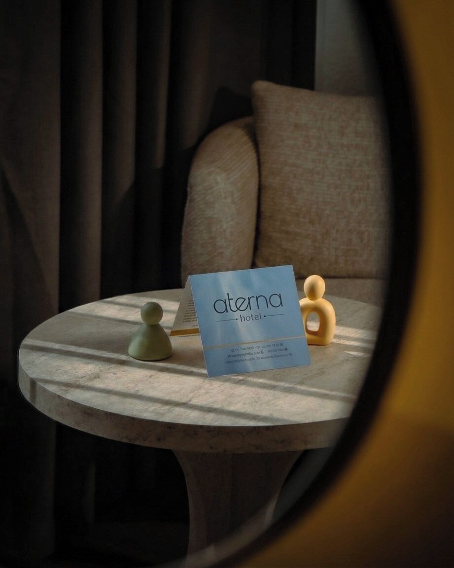 A round table with a sign for 'Aterna Hotel' and two small figurines.
