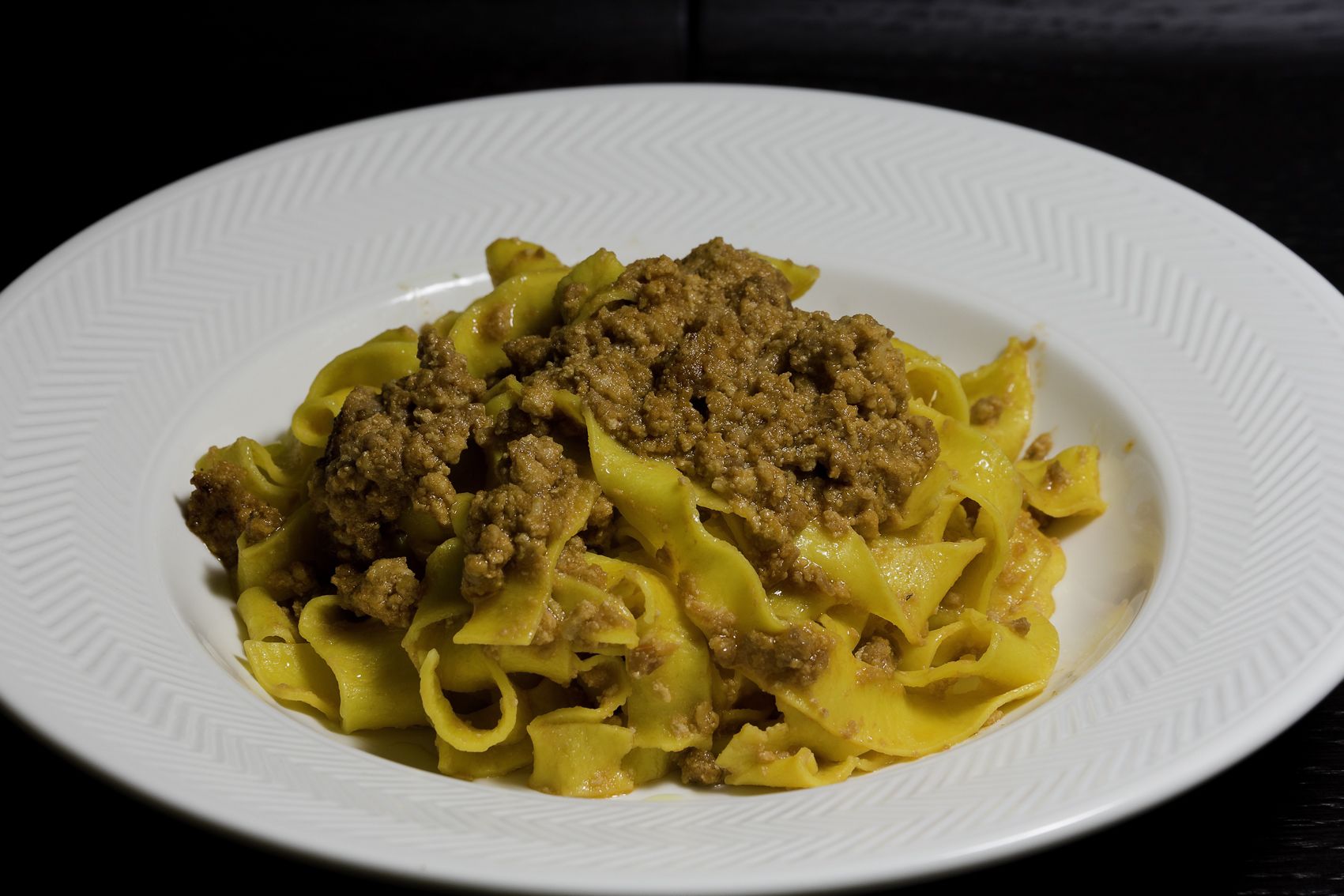 Une assiette de pâtes garnie de viande.