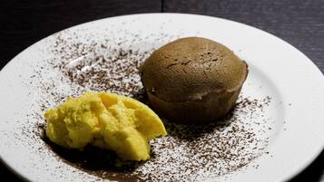 Un postre sobre un plato blanco, espolvoreado con cacao.