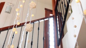A staircase with a string of lights and a woven wall hanging. - Hotel Rural Fonda de la Tea (Tejeda)
