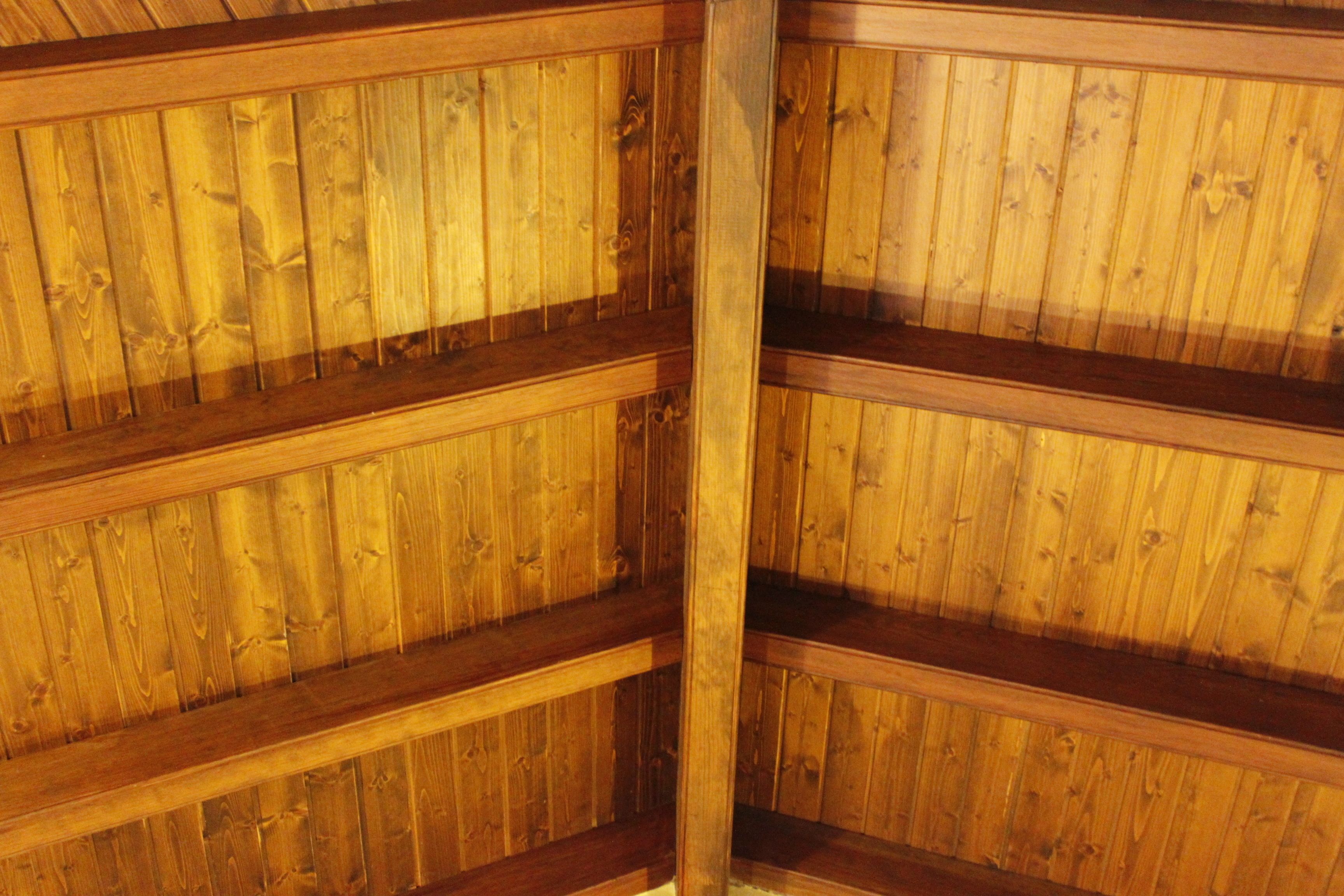 Interior de madera con múltiples vigas horizontales y una columna de soporte central.